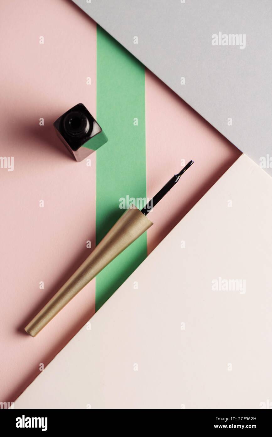 Pinceau traceur liquide, sur fond attrayant, de couleurs rose pastel et vert. Concept de produit et de maquillage. Par le haut Banque D'Images
