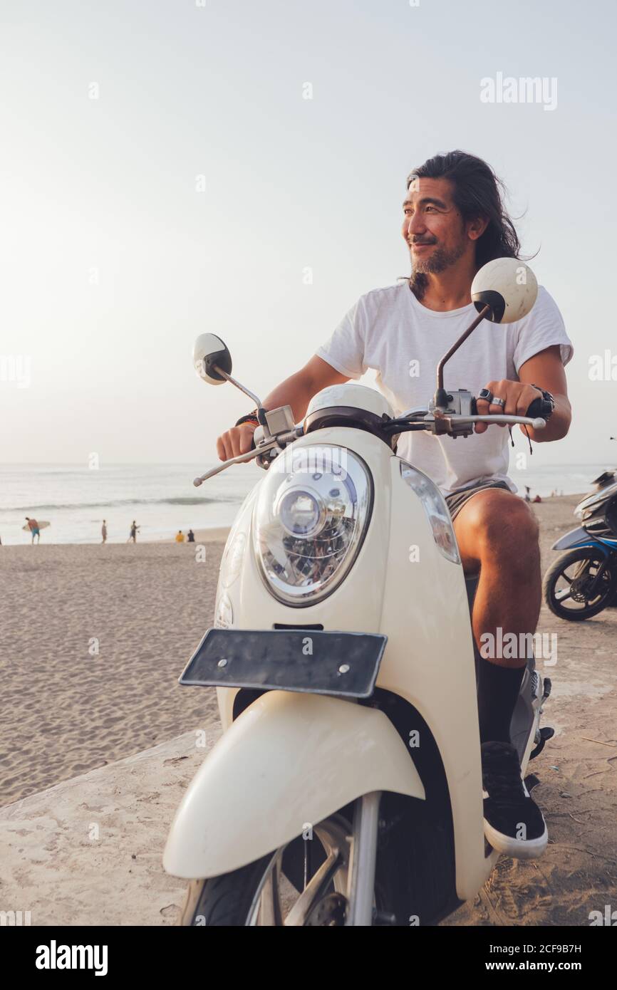Motard joyeux sur une plage de sable Banque D'Images