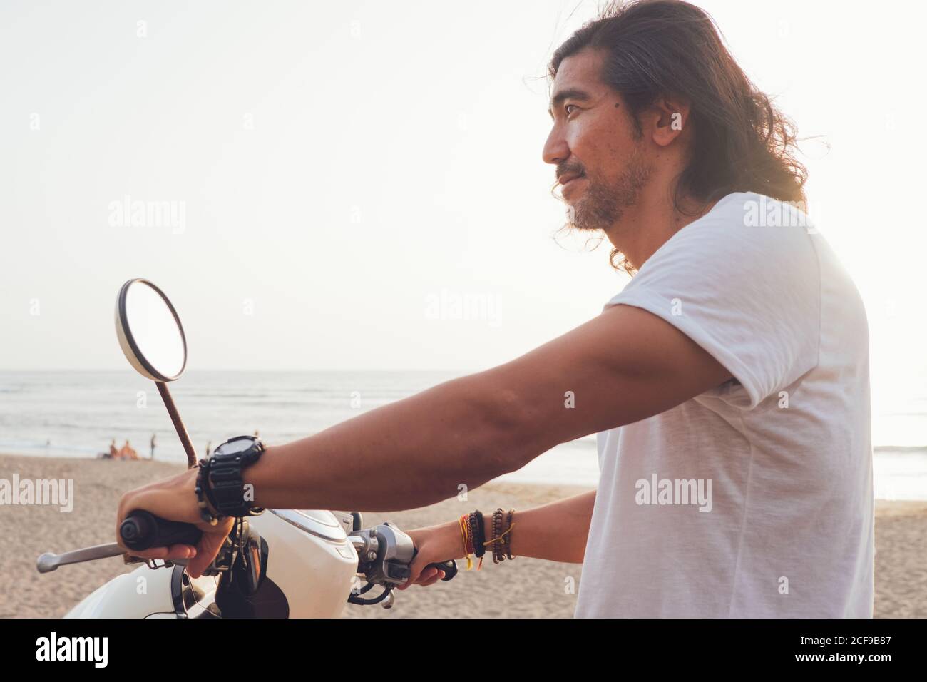 Motard joyeux sur une plage de sable Banque D'Images