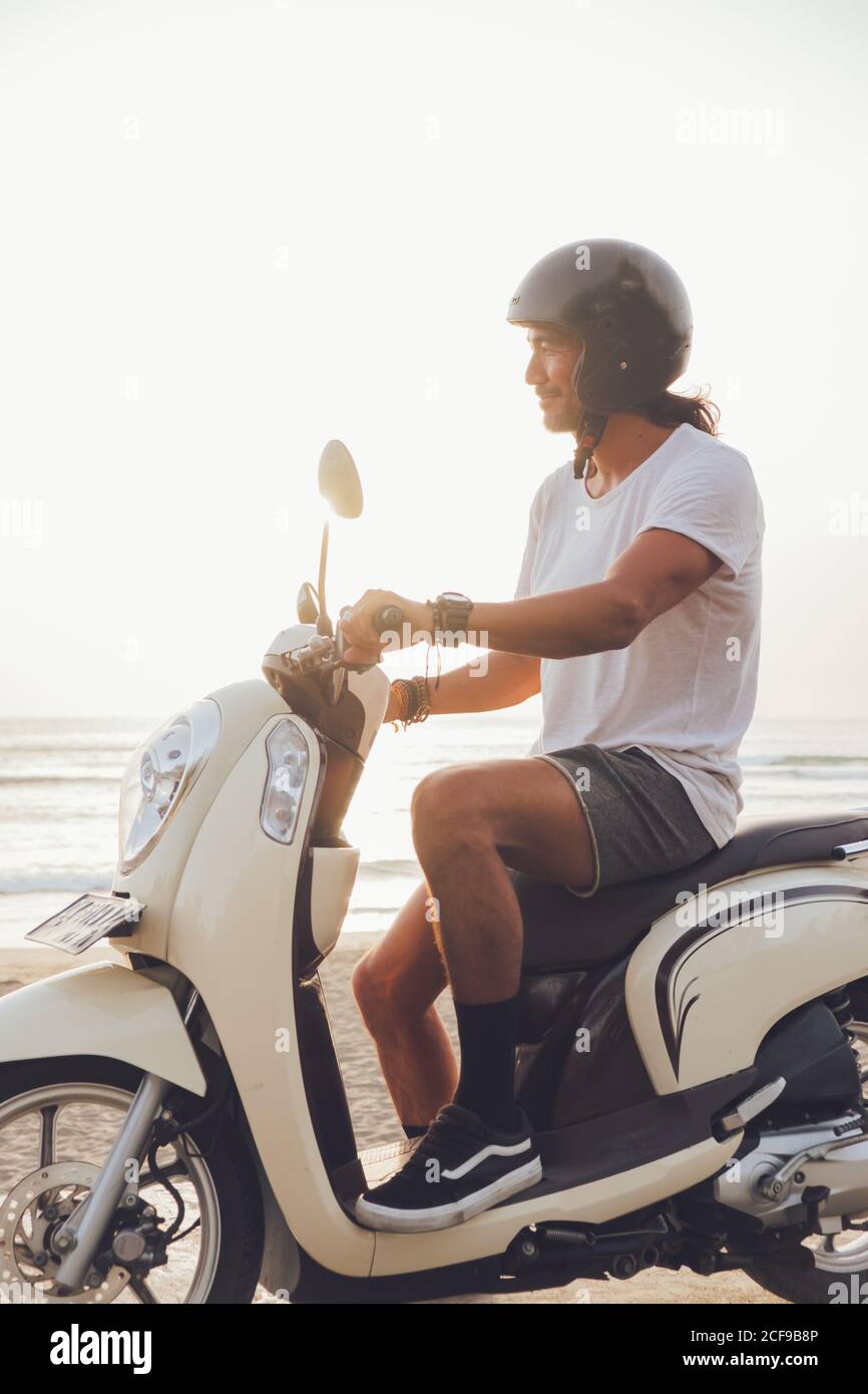 Motard joyeux sur une plage de sable Banque D'Images