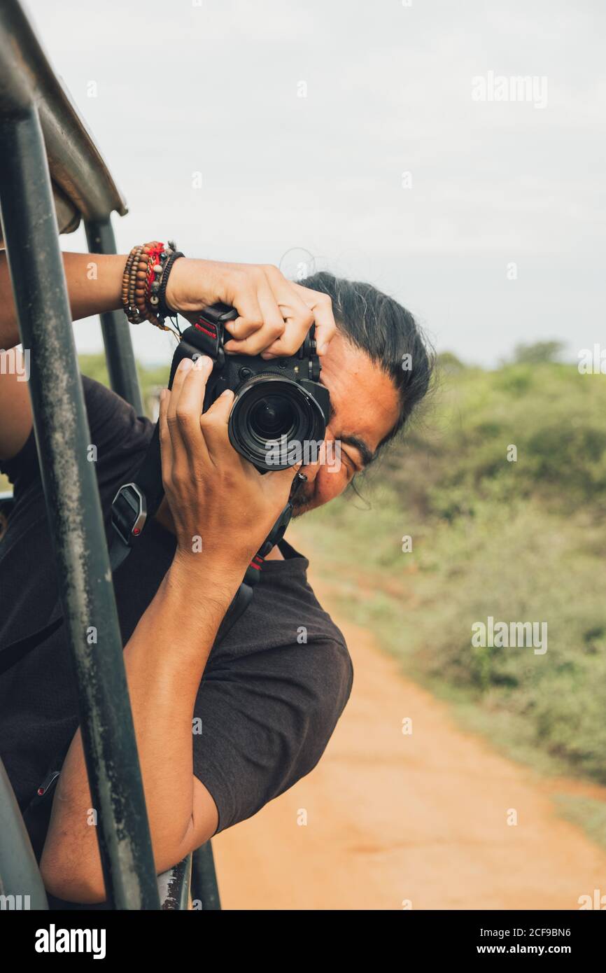 Un homme de voyage heureux avec un appareil photo professionnel qui prend  des photos de faune pendant le safari Photo Stock - Alamy