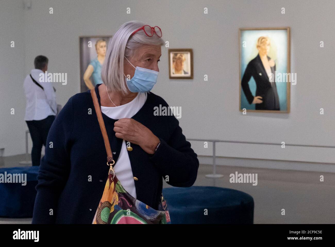 Une femme avec un garde-bouche visite un musée. Banque D'Images