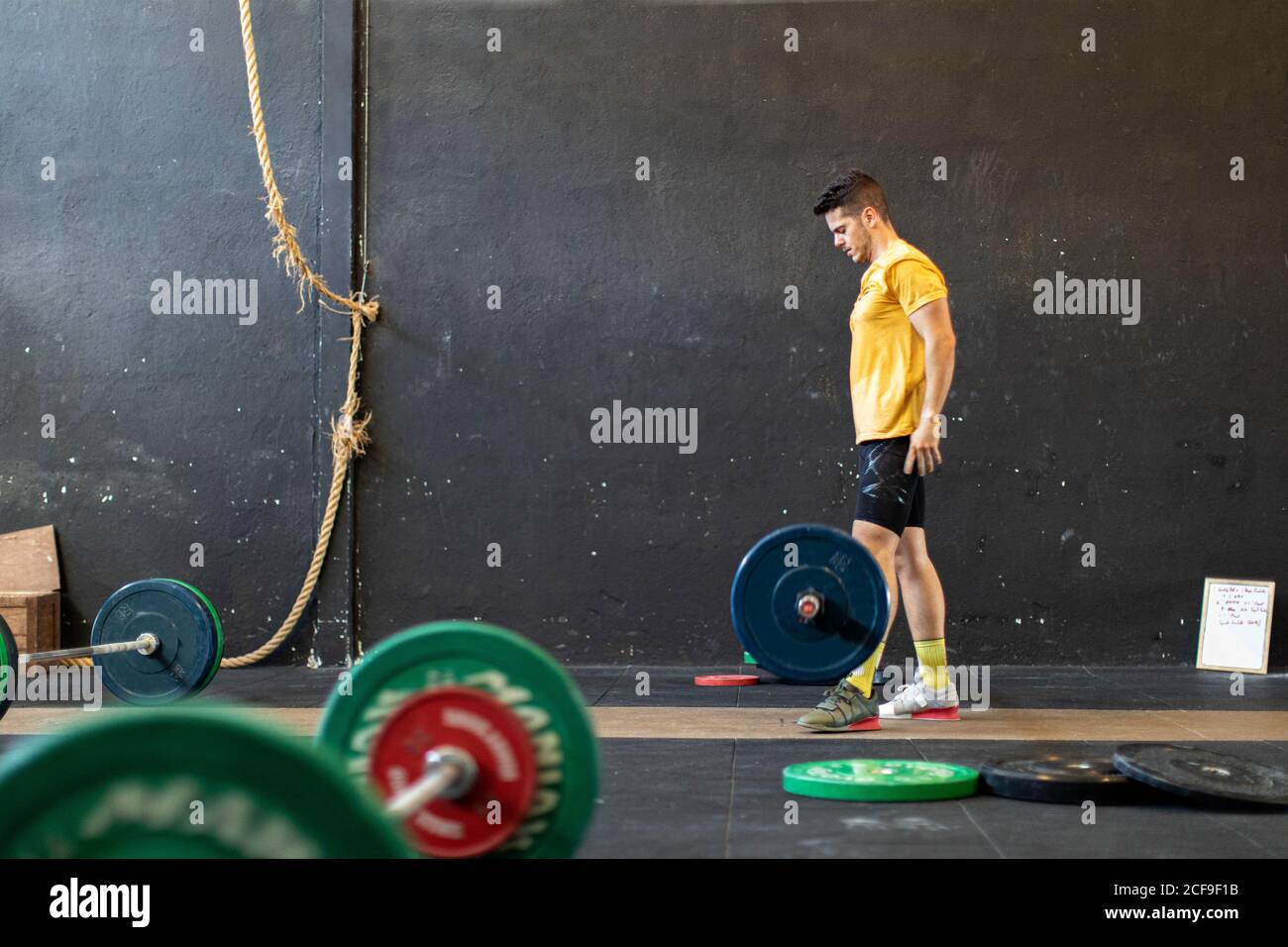 Un homme musclé qui lève la barbell dans une salle de sport moderne Banque D'Images