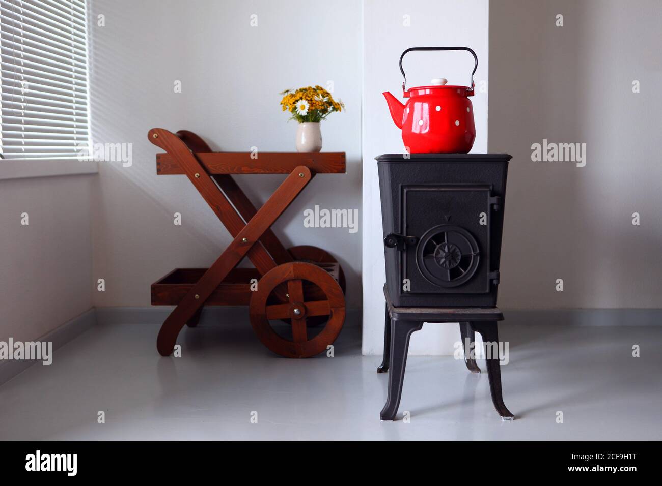 maison de campagne design et intérieur avec four. bouilloire rouge bouillant sur un poêle rétro dans la cuisine. Mise au point sur un bec Banque D'Images