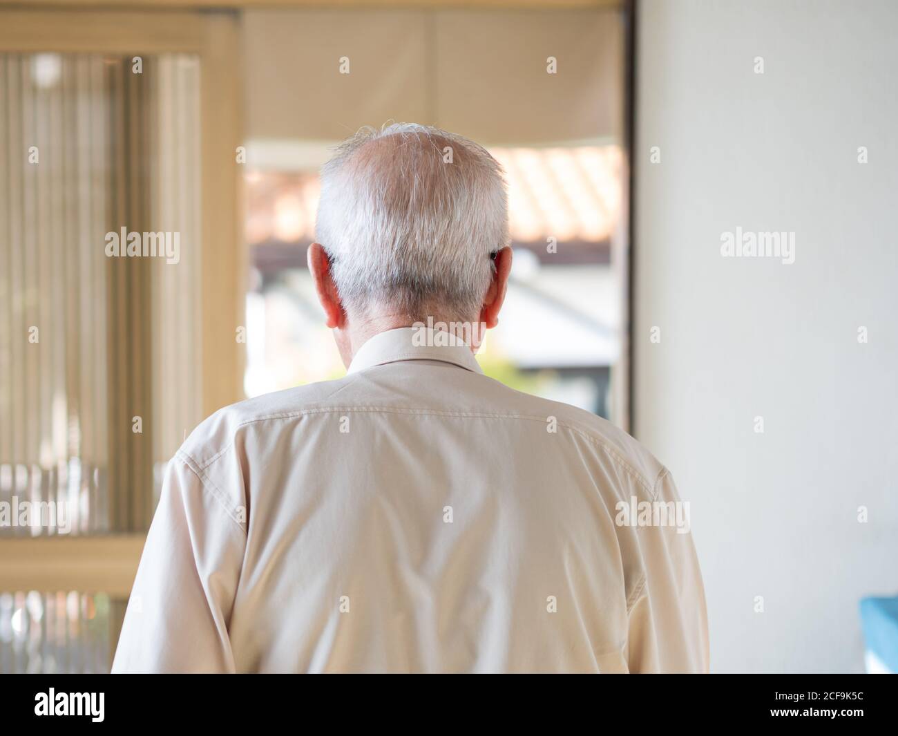 Un vieil homme qui s'éloigne dans une porte lumineuse Banque D'Images