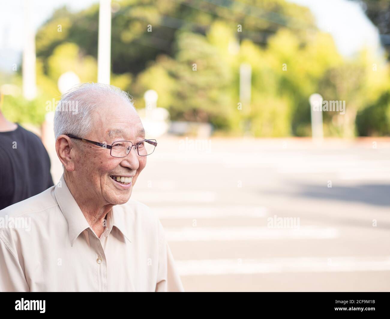 Un homme asiatique âgé souriant à l'extérieur Banque D'Images