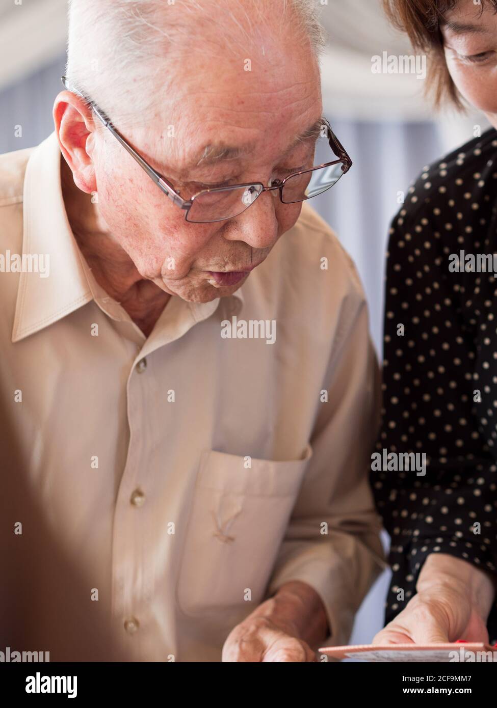 Un homme âgé regardant quelque chose qu'il reçoit avec grand intérêt Banque D'Images