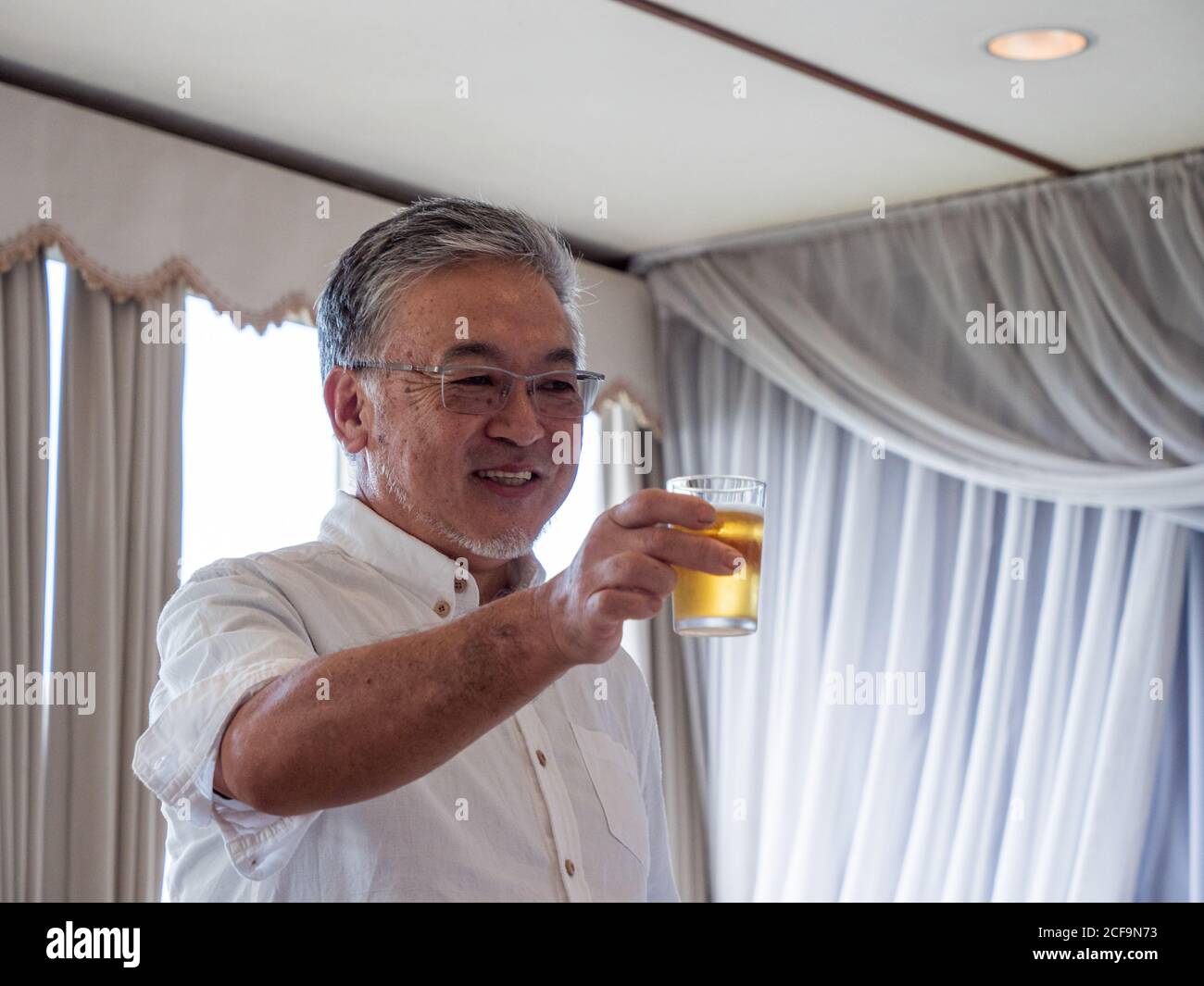 Un homme plus âgé qui toaster lors d'une fête Banque D'Images