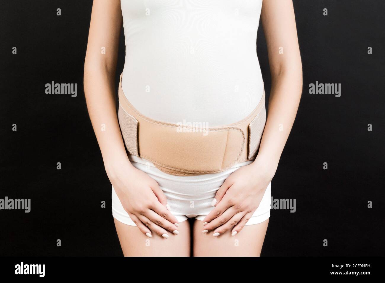 Gros plan de la femme enceinte avec bandage de soutien contre le mal de dos  sur fond noir avec espace de copie. Concept de ceinture de soutien  abdominale orthopédique Photo Stock -