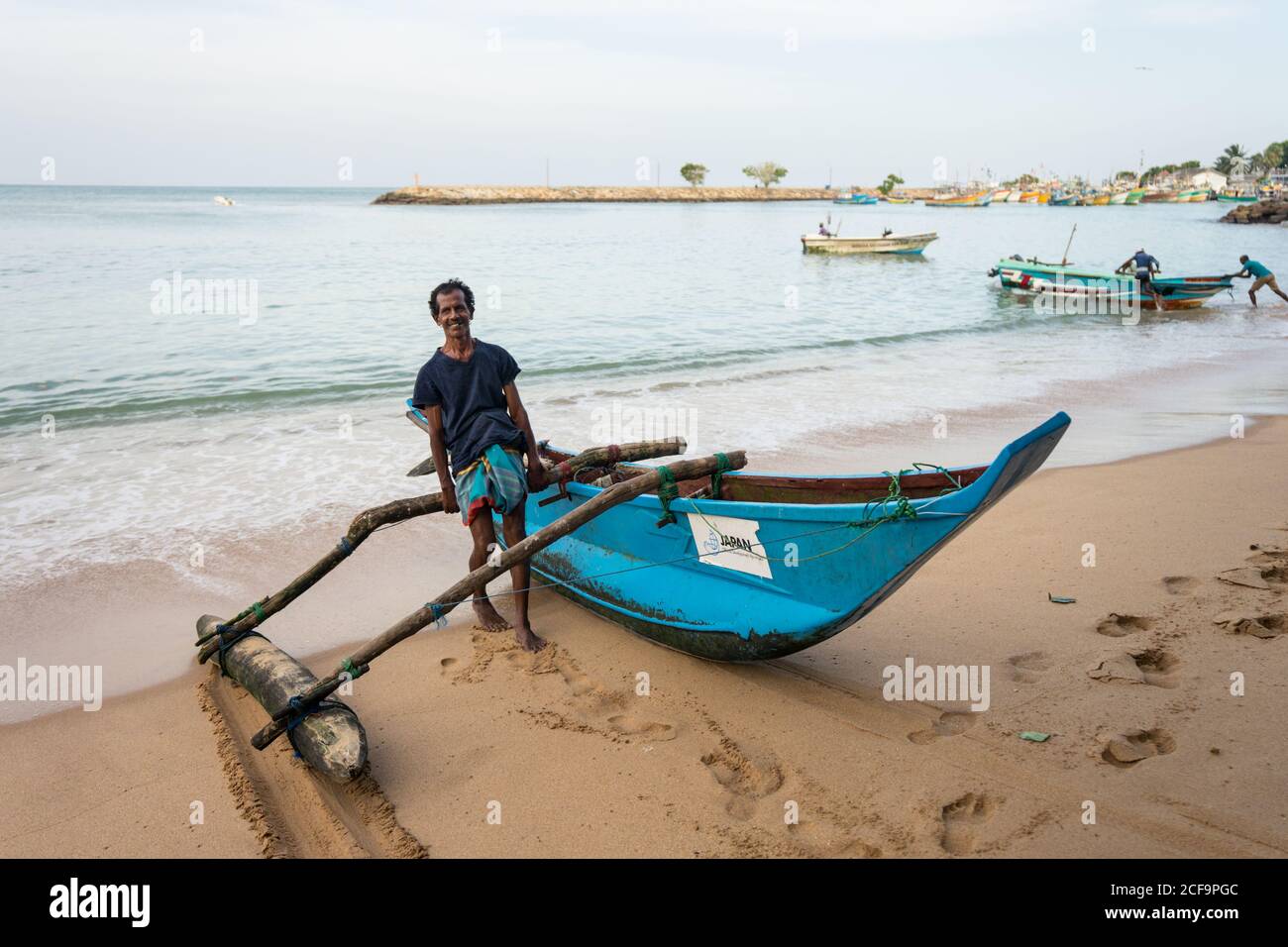 Tangalle, Sri Lanka - 28 juillet 2019 : jeunes pêcheurs ethniques en vêtements décontractés utilisant un bateau traditionnel en mer Banque D'Images