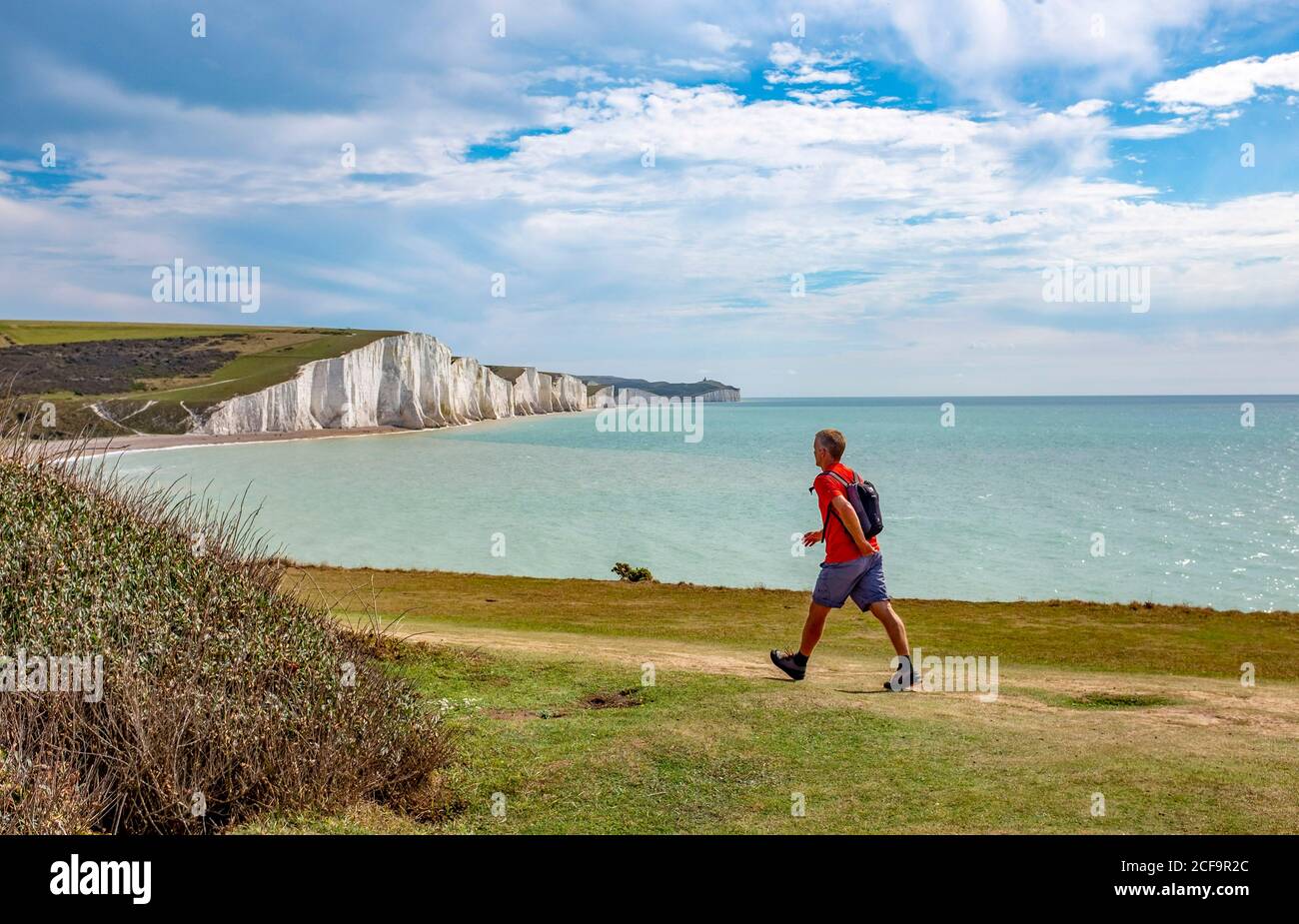 Seaford Royaume-Uni 04 septembre 2020 - UN marcheur bénéficie d'un temps chaud et ensoleillé avec un mélange de nuages sur les falaises surplombant Cuckmere Haven et les Seven Sisters près de Seaford sur la côte du Sussex aujourd'hui . : crédit Simon Dack / Alamy Live News Banque D'Images
