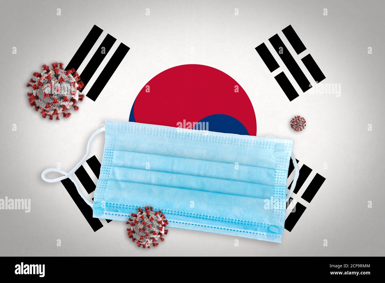 Concept de coronavirus ou de particules Covid-19 et masque chirurgical visage sur le drapeau de la Corée du Sud en arrière-plan. Banque D'Images