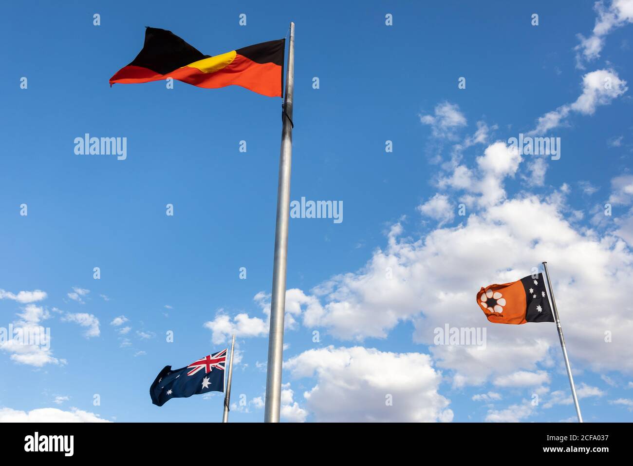 Drapeaux qui se délitent, déplacés par le vent. Trois drapeaux d'Australie, du territoire du Nord et du drapeau aborigène. Mémorial d'Anzac Hill, Alice Springs, Australie Banque D'Images