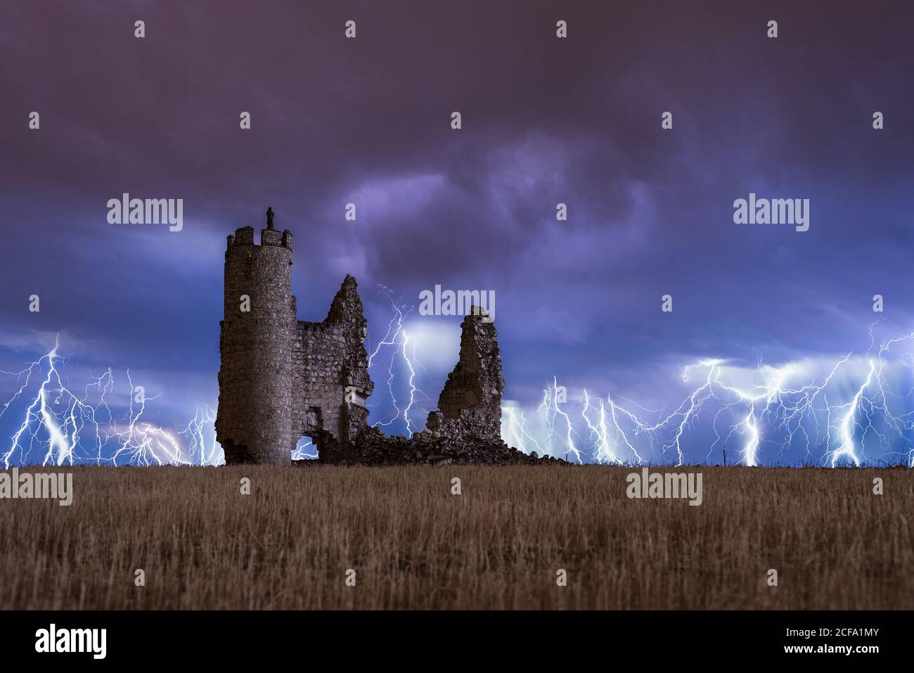 Paysage étonnant d'orage sur ciel nuageux et coloré vieux château en ruines la nuit Banque D'Images