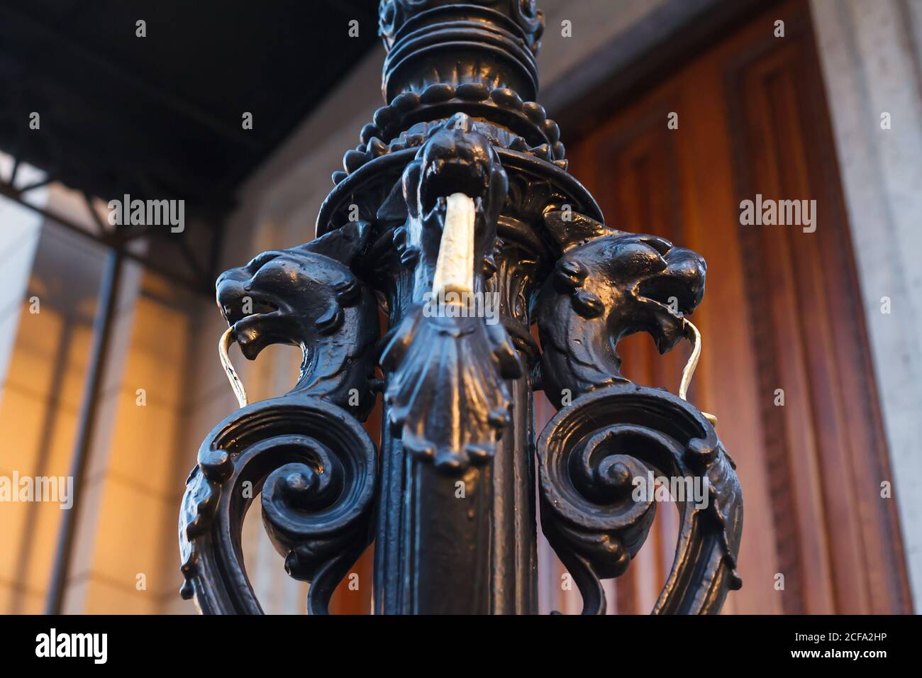 Colonne noire forgée décorative en forme de griffins ou de lignes de floin avec longues languettes dorées Banque D'Images