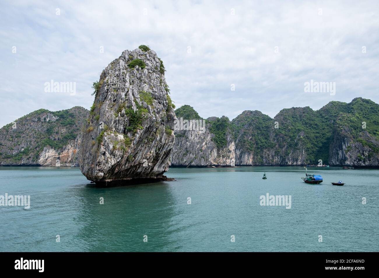 Paysage magique de roche de solitude et de bateaux au milieu de Baie d'Halong au Vietnam Banque D'Images