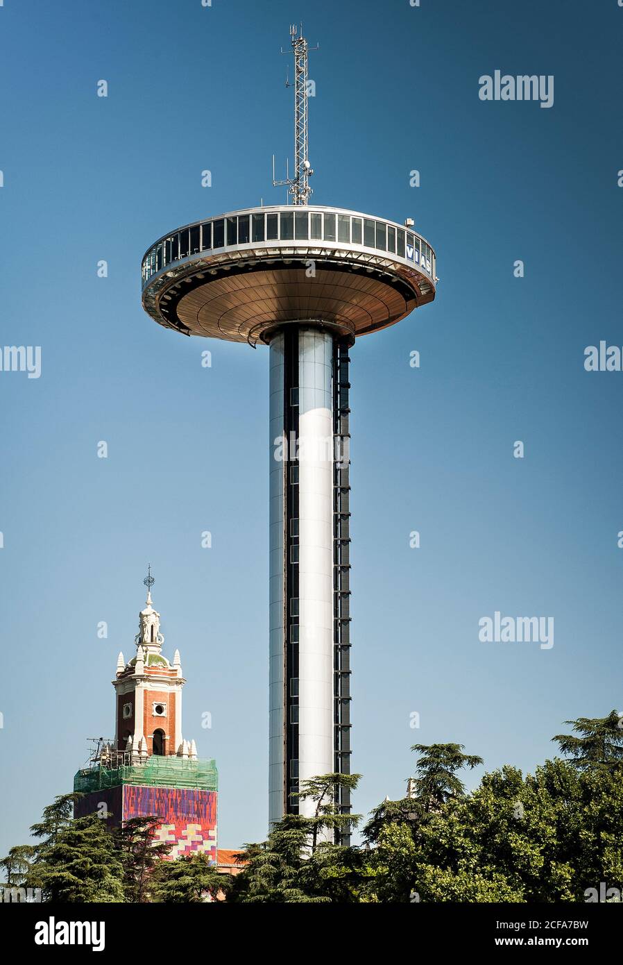 Conception de la tour de transmission Faro de Moncloa en haut arbres verts contre ciel bleu Banque D'Images