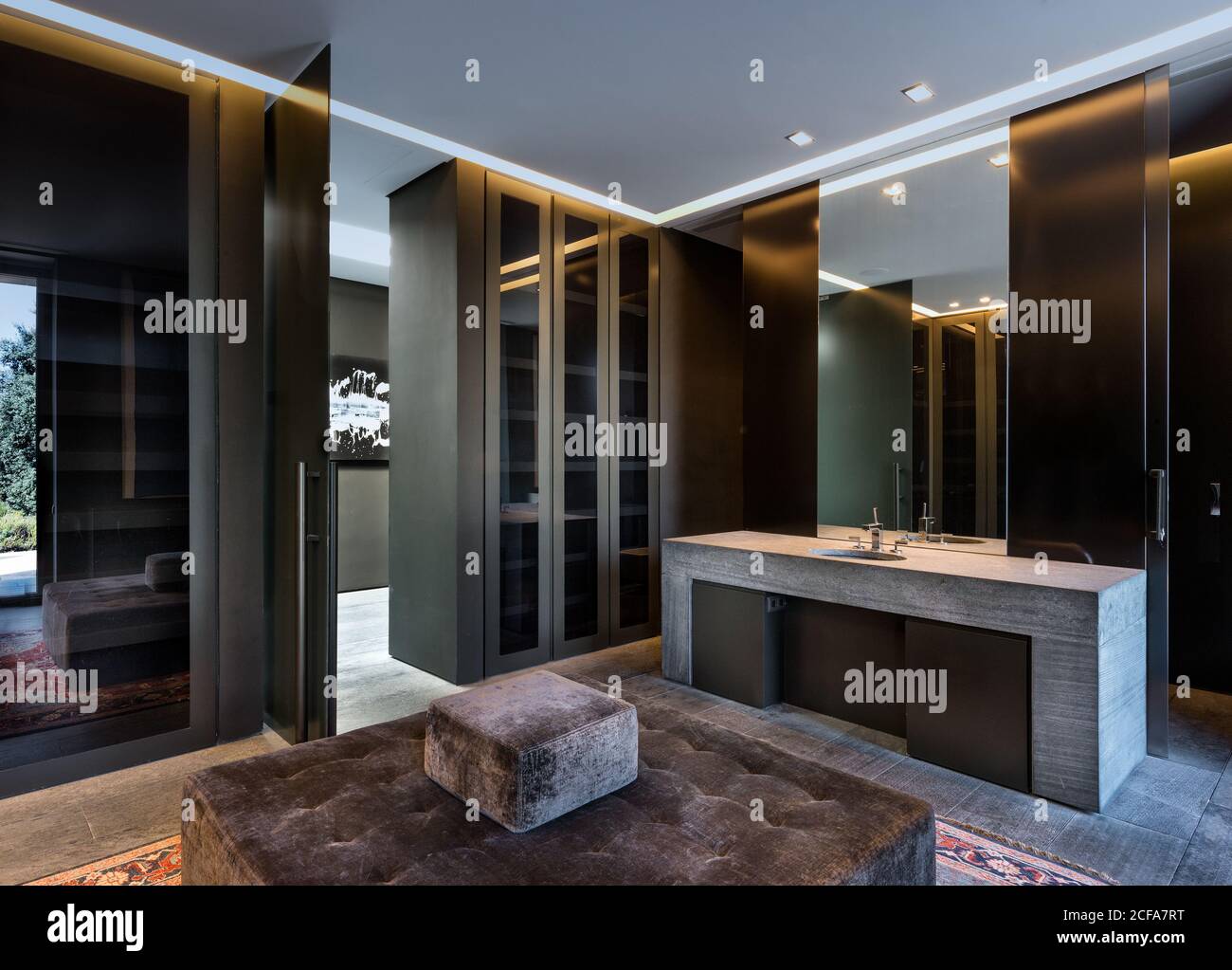 Salle de bains contemporaine avec portes en verre et lavabo en pierre éclairé par lampes modernes Banque D'Images