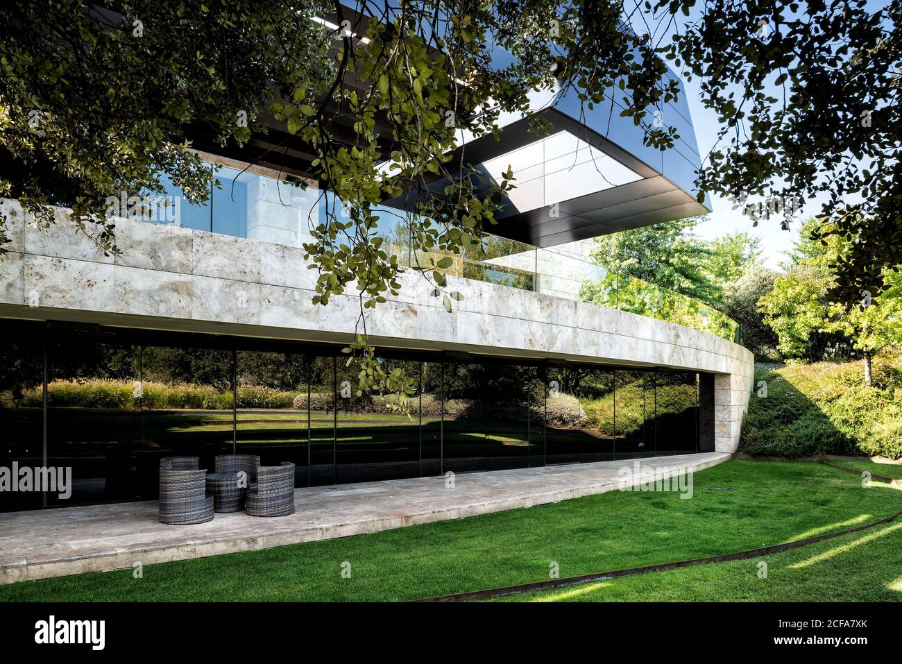 Façade d'un immense bâtiment contemporain de style futuriste avec une végétation luxuriante pelouse dans l'arrière-cour Banque D'Images