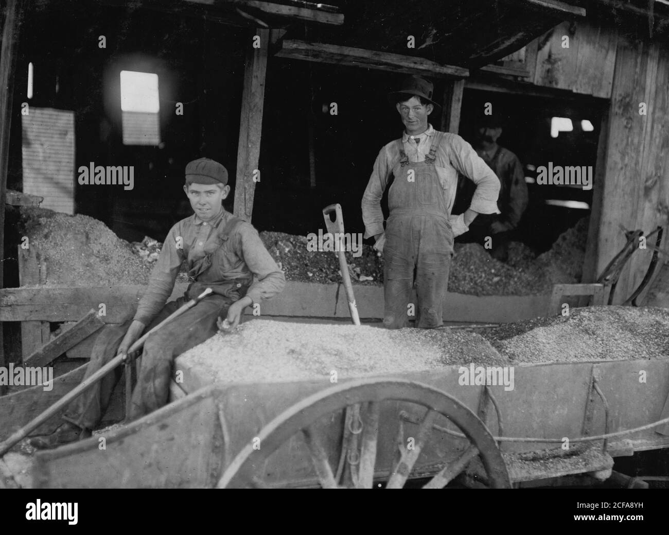 Garçon de 14 ans à des travaux pénibles. Pelleter de minerai à la mine Bell Daisy, Aurora, Banque D'Images