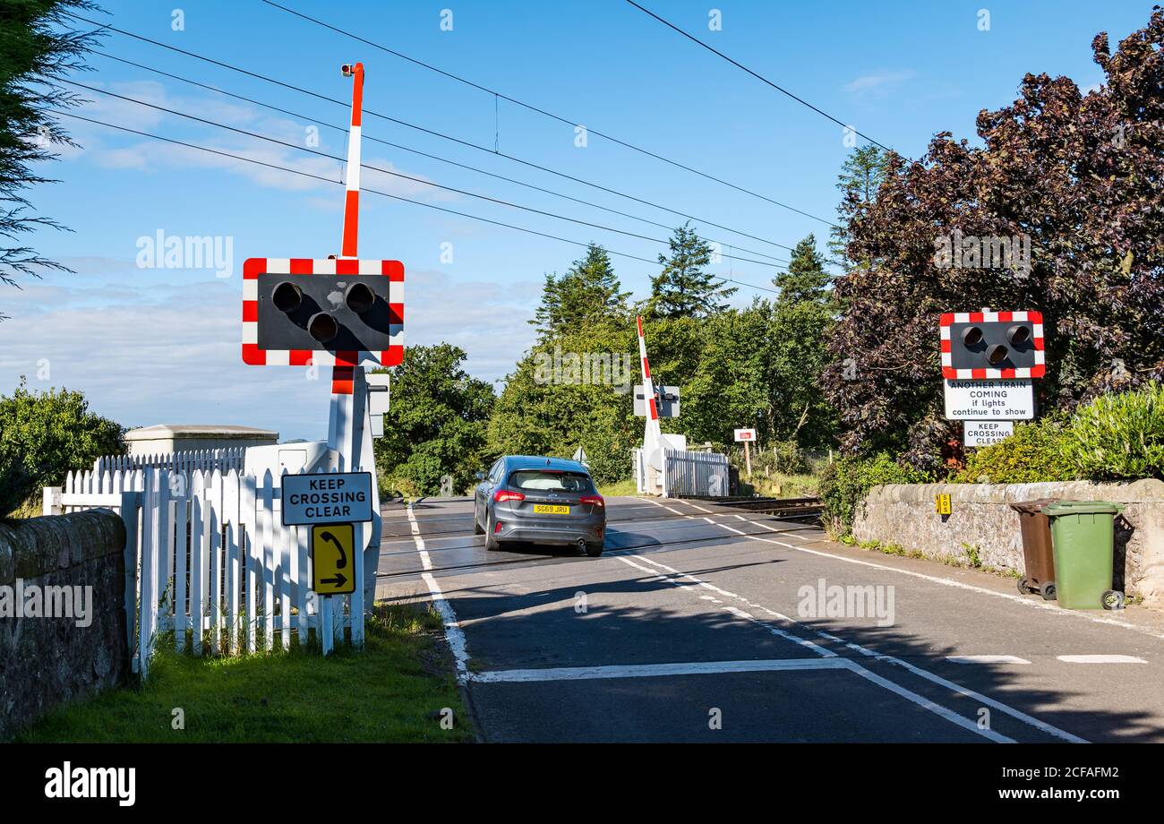 Barrière de sécurité et voiture sur le passage à niveau de la ligne de chemin de fer principale de la côte est, Markle, East Lothian, Écosse, Royaume-Uni Banque D'Images