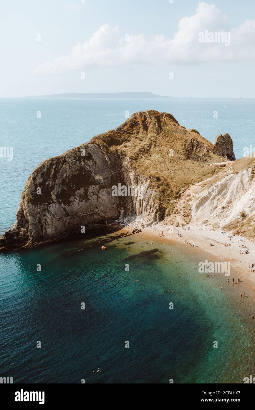 Depuis le haut paysage idyllique de mer avec des rochers appelés Durdle Door et les gens se détendent sur la mer le jour de l'été Banque D'Images