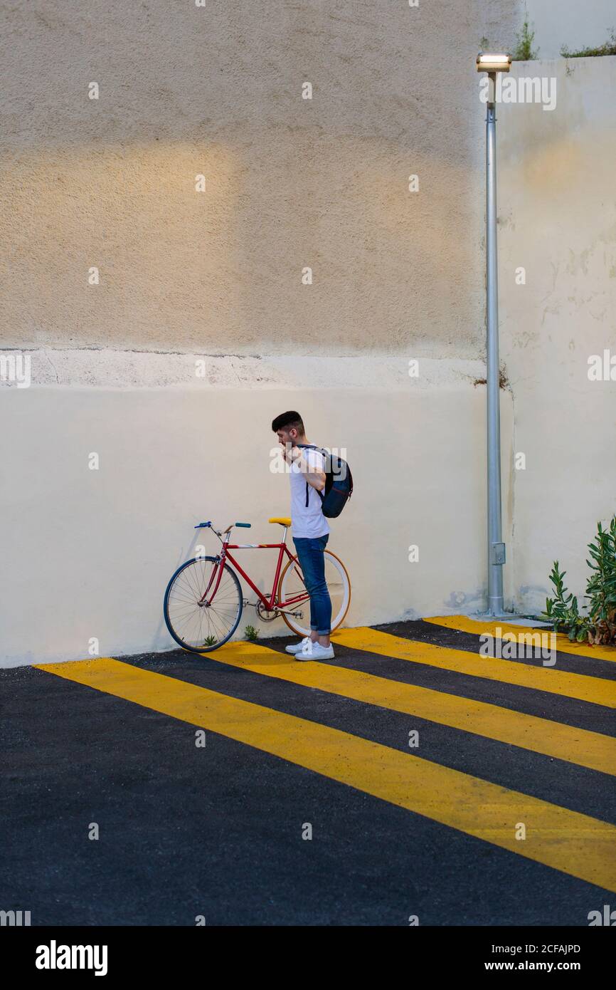 Un homme de race blanche prend son sac à dos pour faire du vélo fixe Banque D'Images