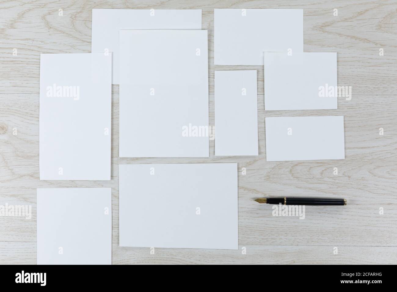 Une feuille de papier blanc et un stylo sur une table en bois Banque D'Images