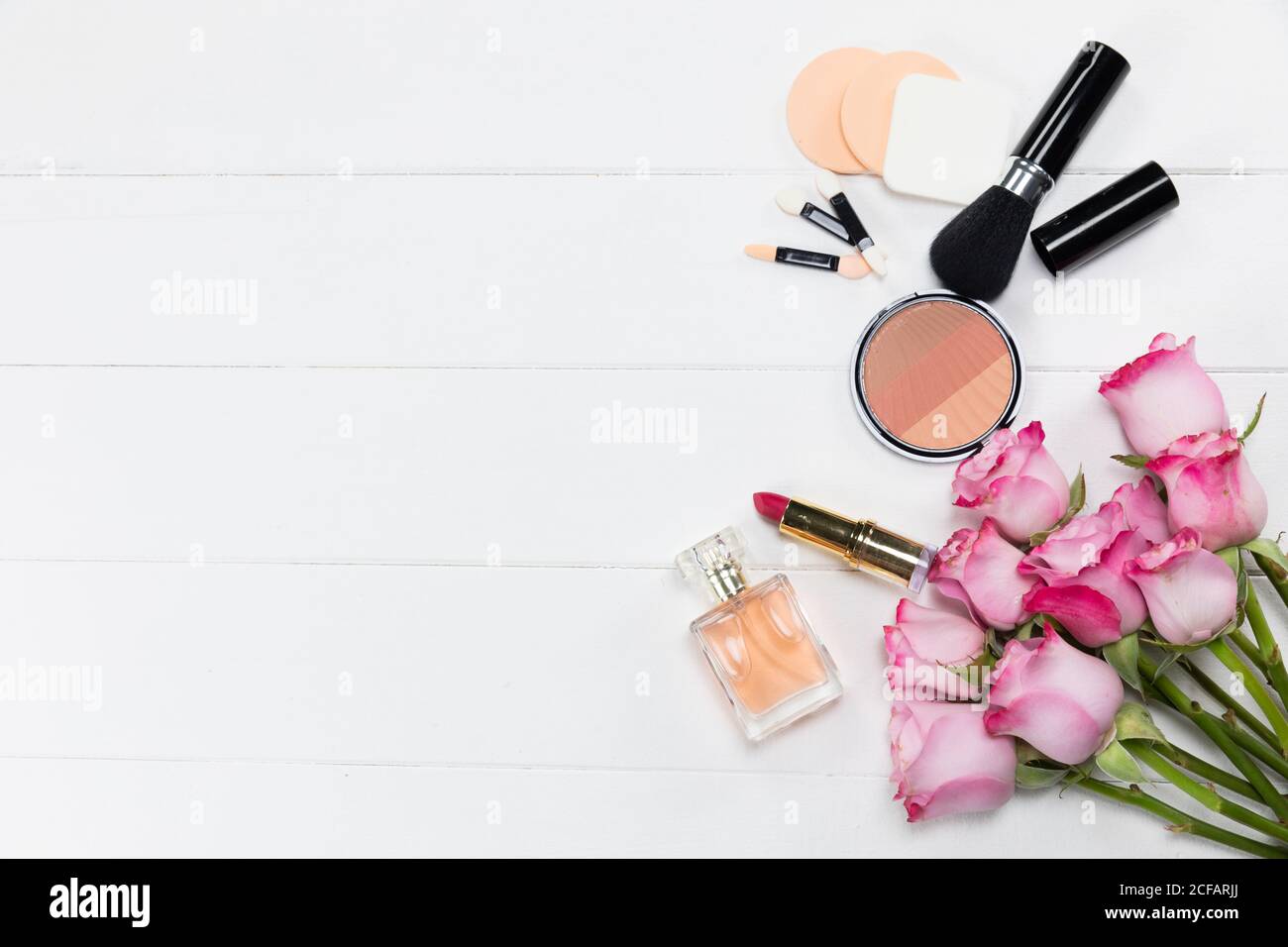 Maquillage avec fleurs roses et parfum sur blanc arrière-plan Banque D'Images