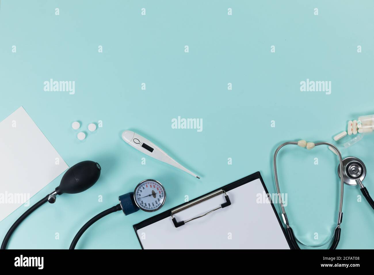 Vue d'une composition avec des dispositifs médicaux, des pilules et un dossier avec une feuille de papier sur une surface bleue Banque D'Images