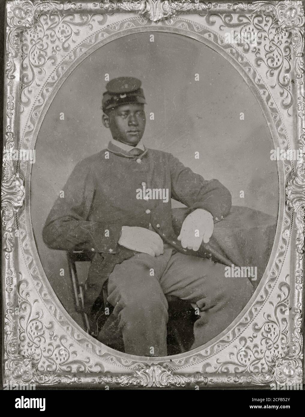 Soldat noir assis, redingote, gants, képi Banque D'Images