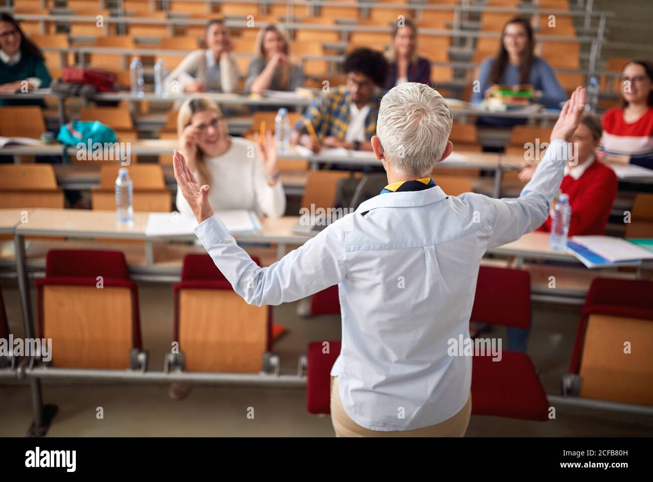 Vue arrière d'une femme professeur avec des étudiants en amphithéâtre Banque D'Images