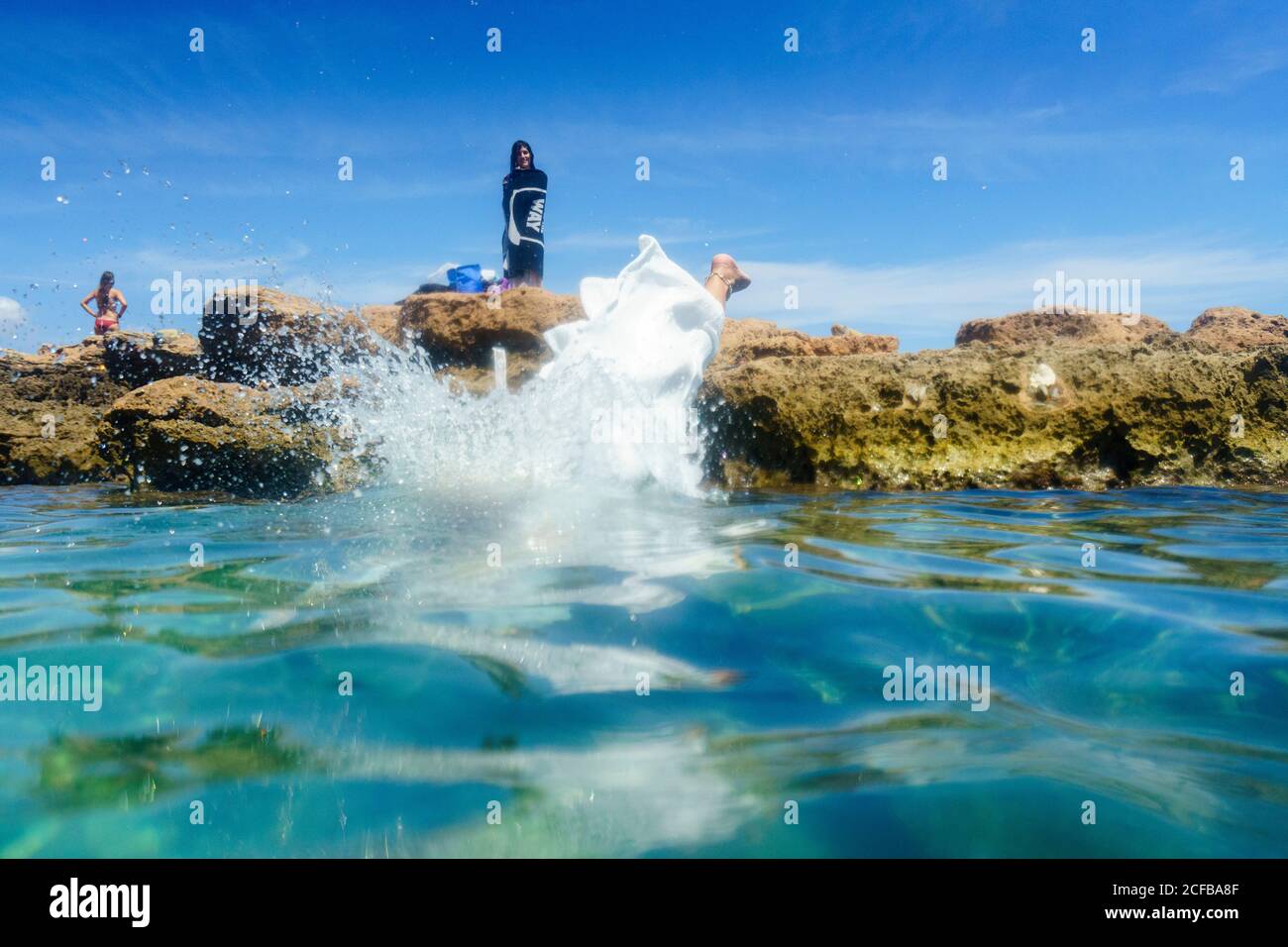 Une femme saute tête dans l'eau dans un blanc robe Banque D'Images