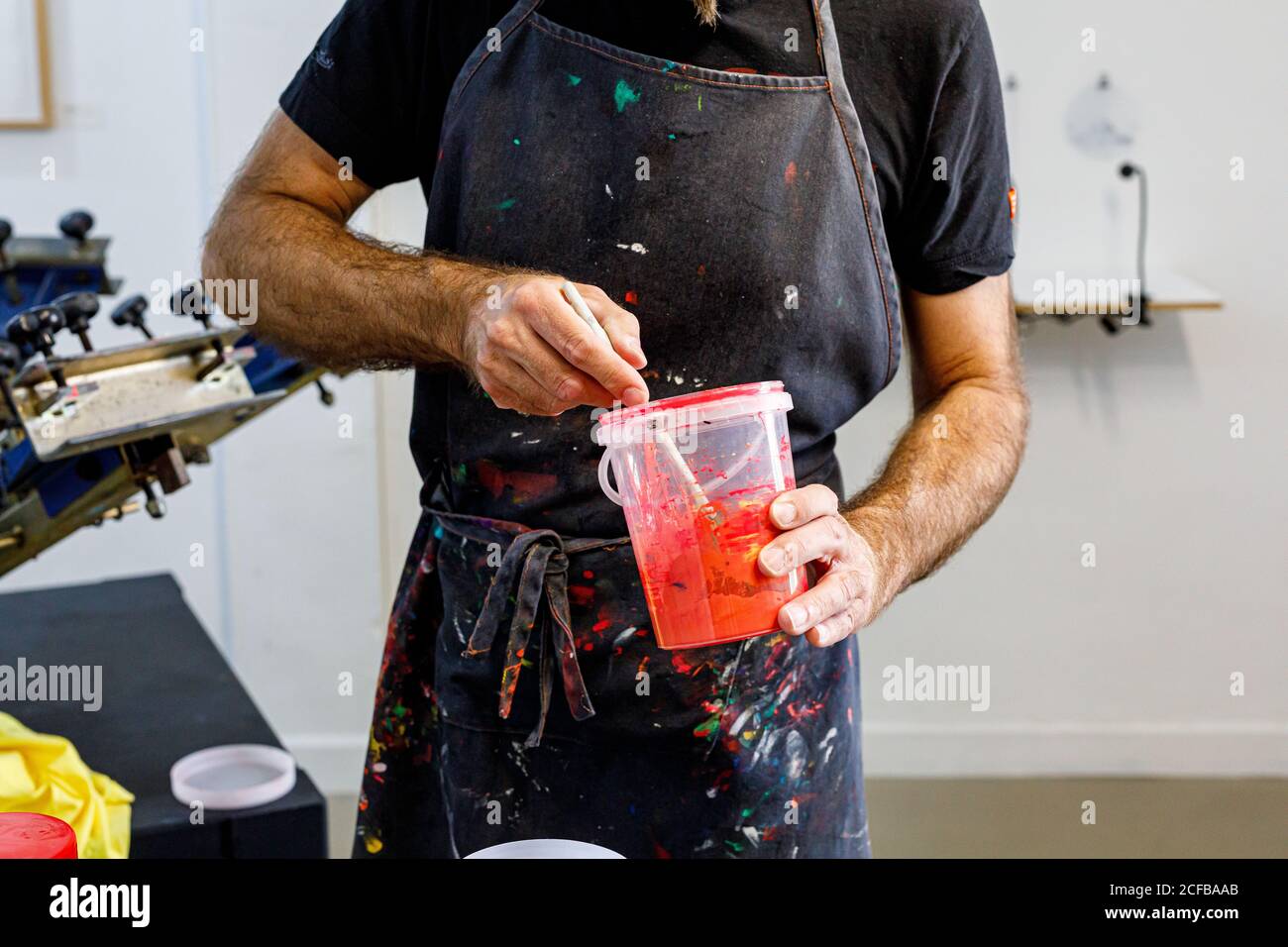 Récolte concentrée homme portant un tablier sale mélange de diverses  peintures pour sérigraphie en atelier Photo Stock - Alamy