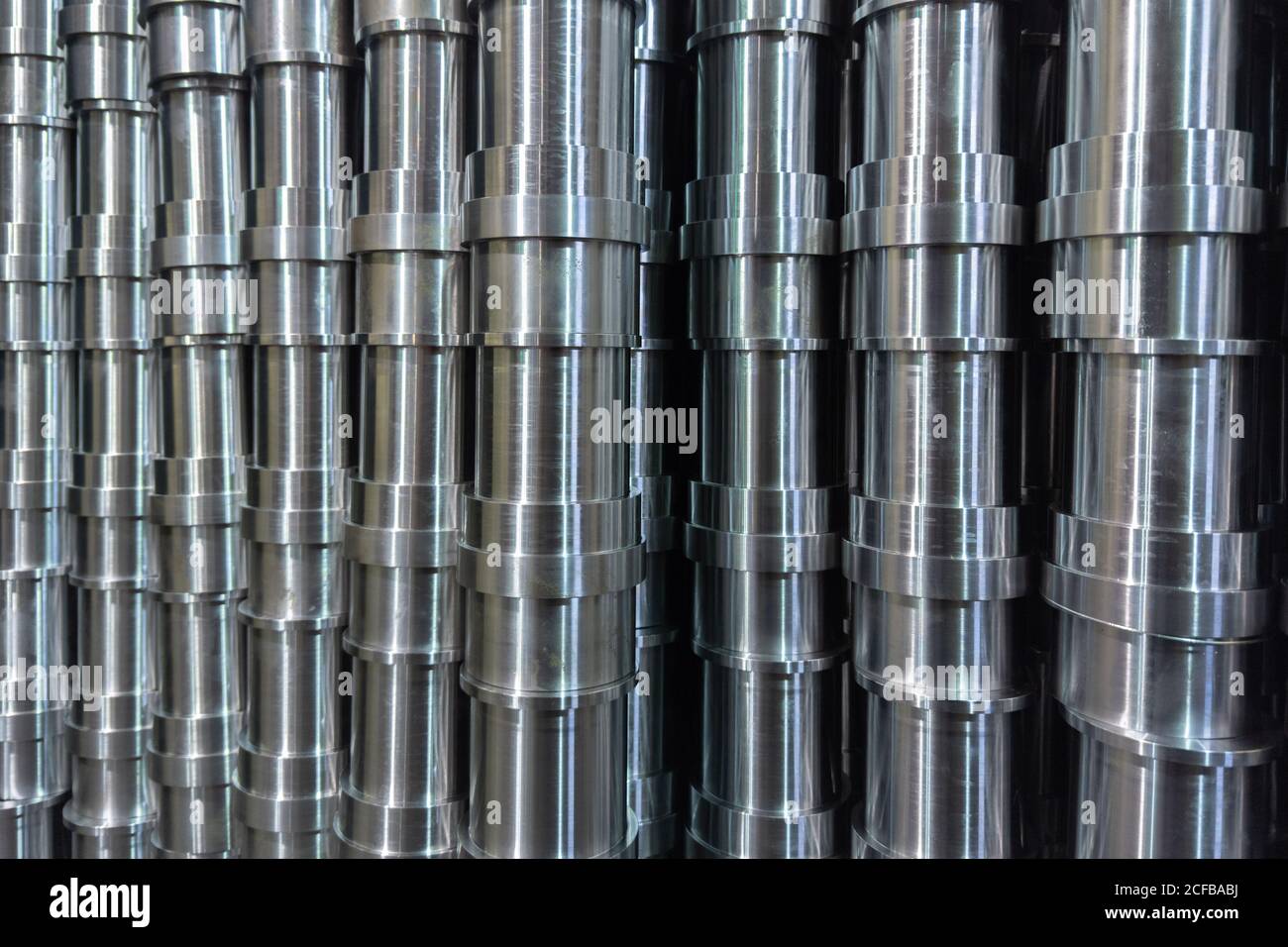 résumé de production industrielle en acier brillant empilé plein cadre avec tuyaux usinés cnc - mise au point sélective et technique de flou d'objectif Banque D'Images