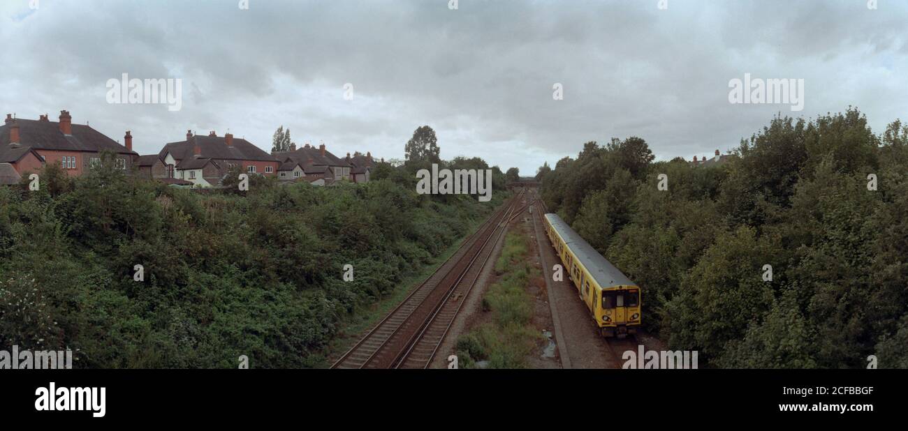 Liverpool, Royaume-Uni - 20 août 2020 : les pistes de la banlieue de Liverpool. Un train électrique Merseyrail quittant la gare de Hunt Cross. Banque D'Images