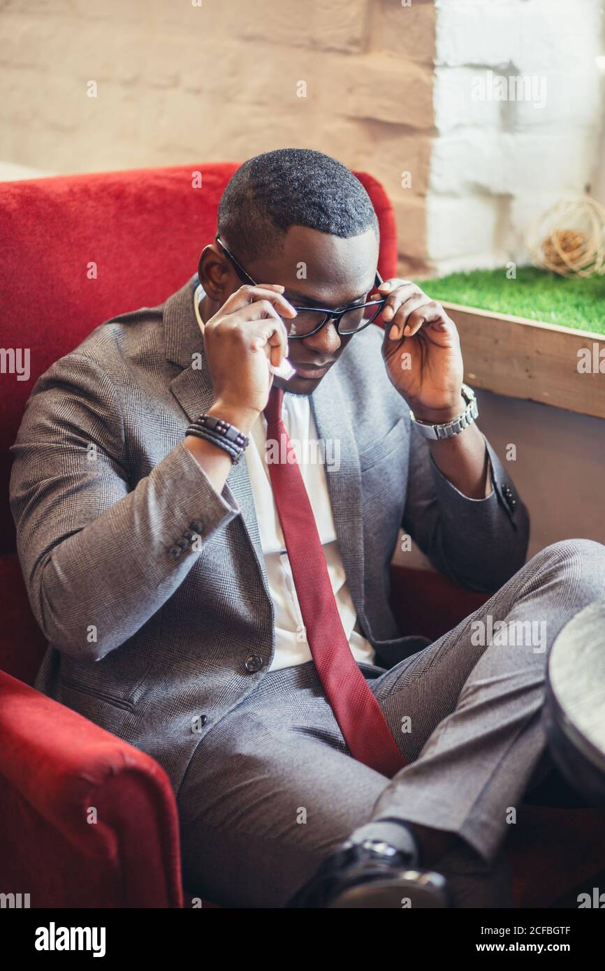 Portrait d'un jeune homme d'affaires afro-américain confiant et réussi portant des lunettes élégantes et un élégant costume sombre habillé sourire heureux, réjouissez-vous Banque D'Images