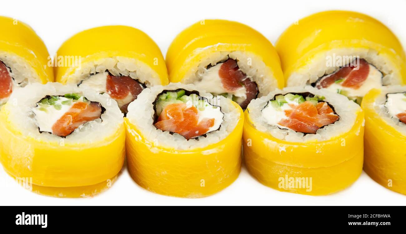 Sushi roulés avec takuan et saumon fumé sur une assiette blanche, sushis japonais classiques. Cuisine japonaise traditionnelle avec maki délicieux sushis pour le menu du restaurant. Copier l'espace Banque D'Images