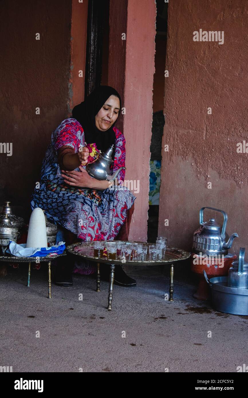 Berbère femme préparant et versant du thé à la menthe marocaine Banque D'Images