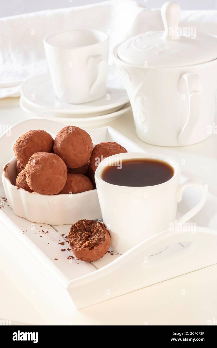 Truffes au chocolat vegan maison cacao poudre blanc assiette lumière du matin. Concept de bonbons diététiques sains et savoureux. Banque D'Images