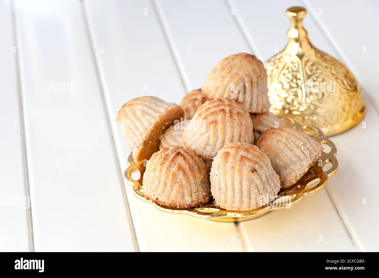 Maamoul pâtisserie traditionnelle arabe ou biscuit aux dattes ou noix de cajou ou d'amande ou de pistaches noix dans une assiette dorée. Bonbons de l'est. Gros plan Banque D'Images
