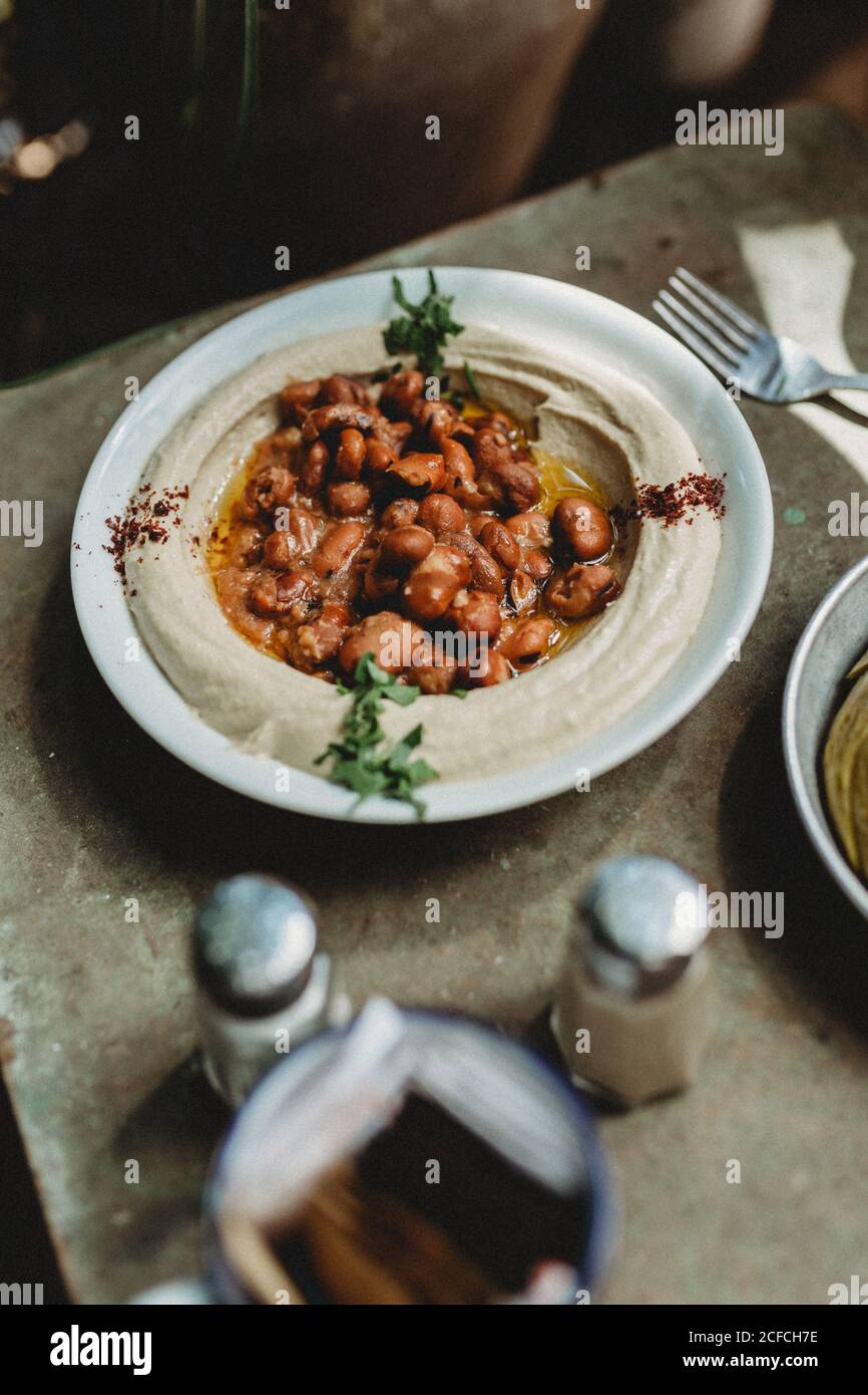 houmous de haricots dans l'assiette près de l'assiette de légumes Banque D'Images