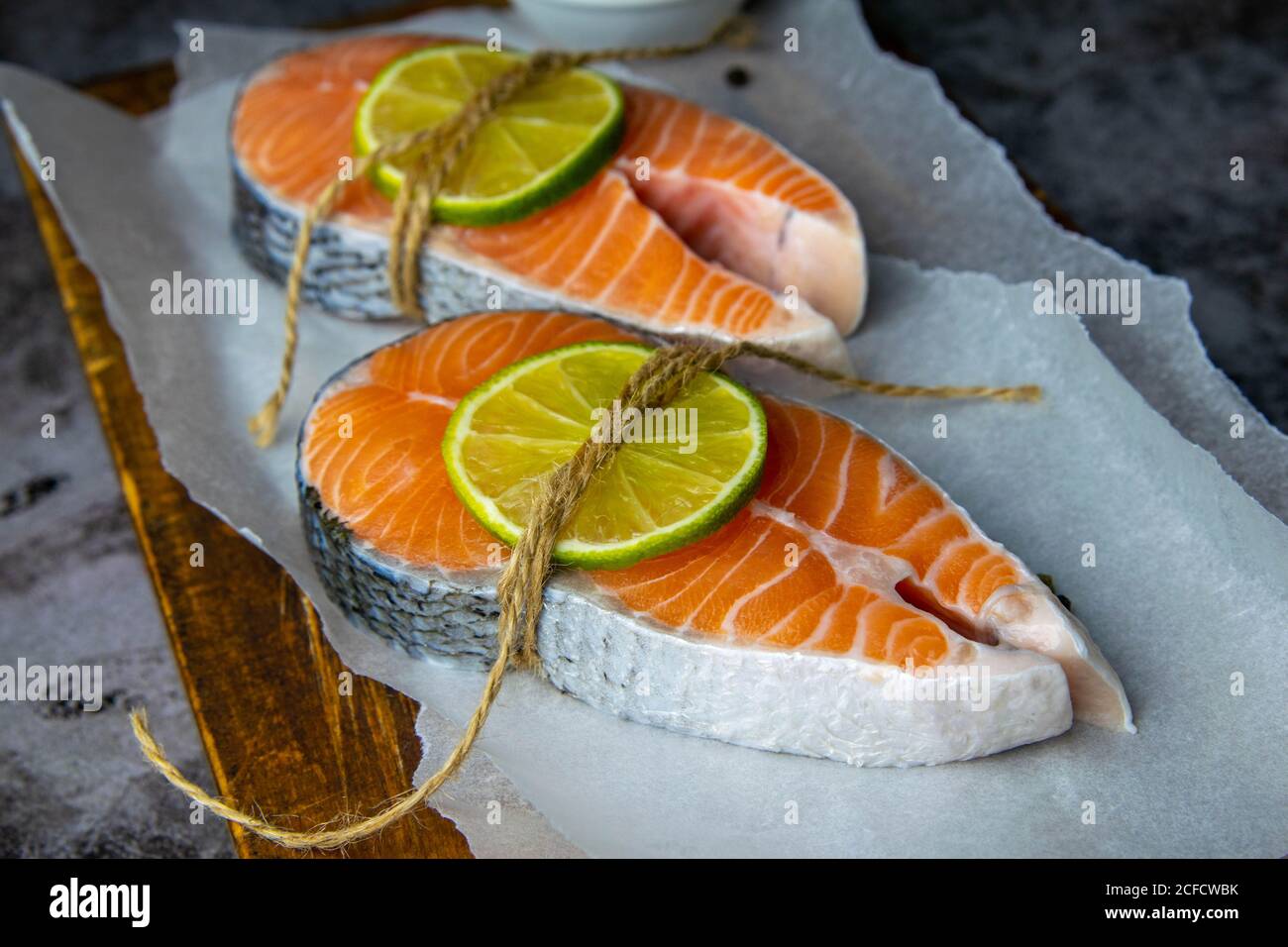 Deux steaks de poisson rouge crus et citron vert et prêt à cuire. Gros plan Banque D'Images