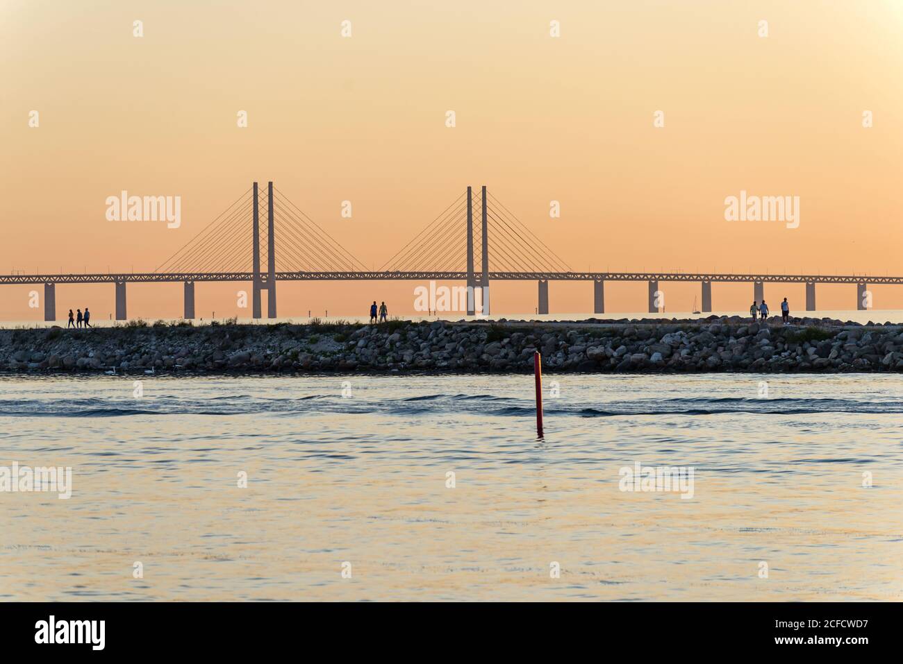 Vue latérale du pont Øresund dans la lumière du soir, marcheurs sur la jetée en premier plan Banque D'Images