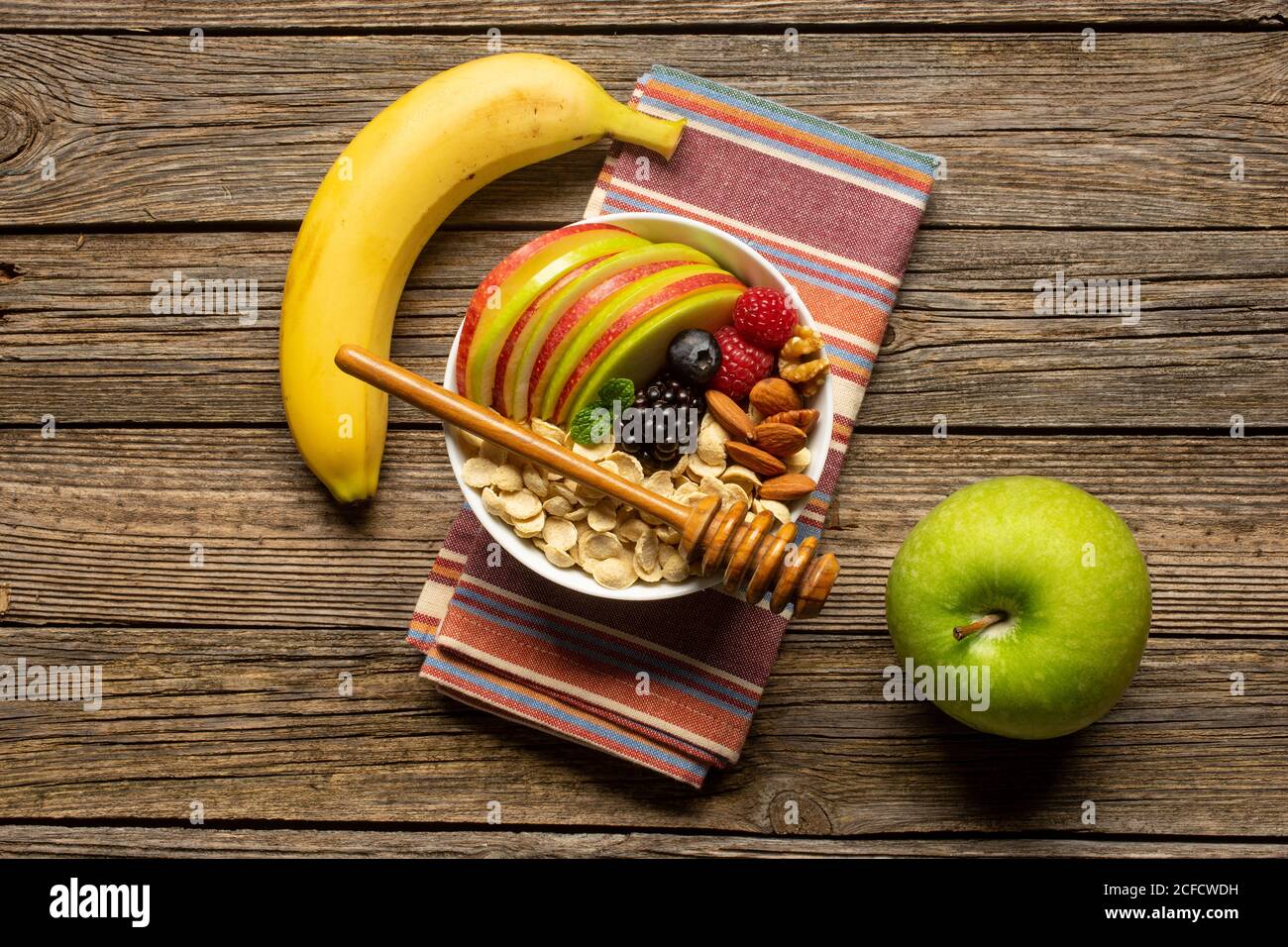 Bol avec fruits à coque et baies avec un balancier au miel Banque D'Images