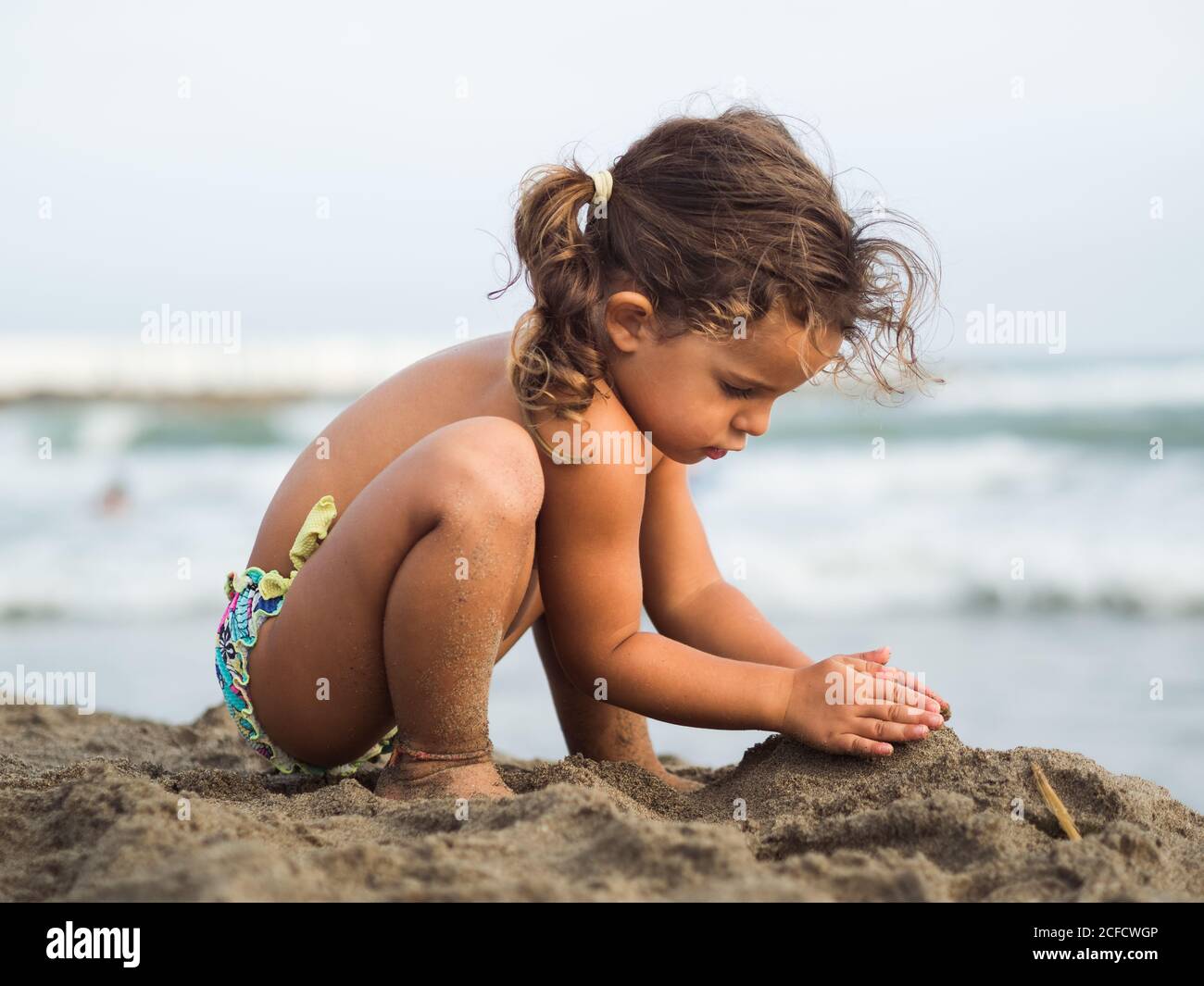 Vue Laterale D Une Petite Fille Mignonne Avec Des Queues De Porc Essayant De Le Faire Faites Un Chateau De Sable En Jouant Sur La Plage Pres De La Mer Sur La Station