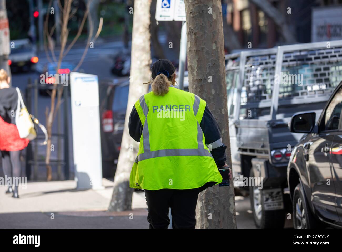 Australian council ranger dans le centre-ville de Sydney, en Nouvelle-Galles du Sud, Australie faisant respecter le conseil local lois et lois au revoir Banque D'Images