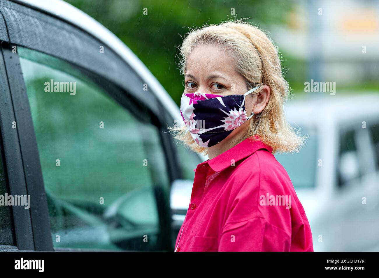 Pandemic COVID19 - Portrait de profil de la femme de race mixte portant un masque en tissu maison de bricolage pour la protection contre le coronavirus. Banque D'Images