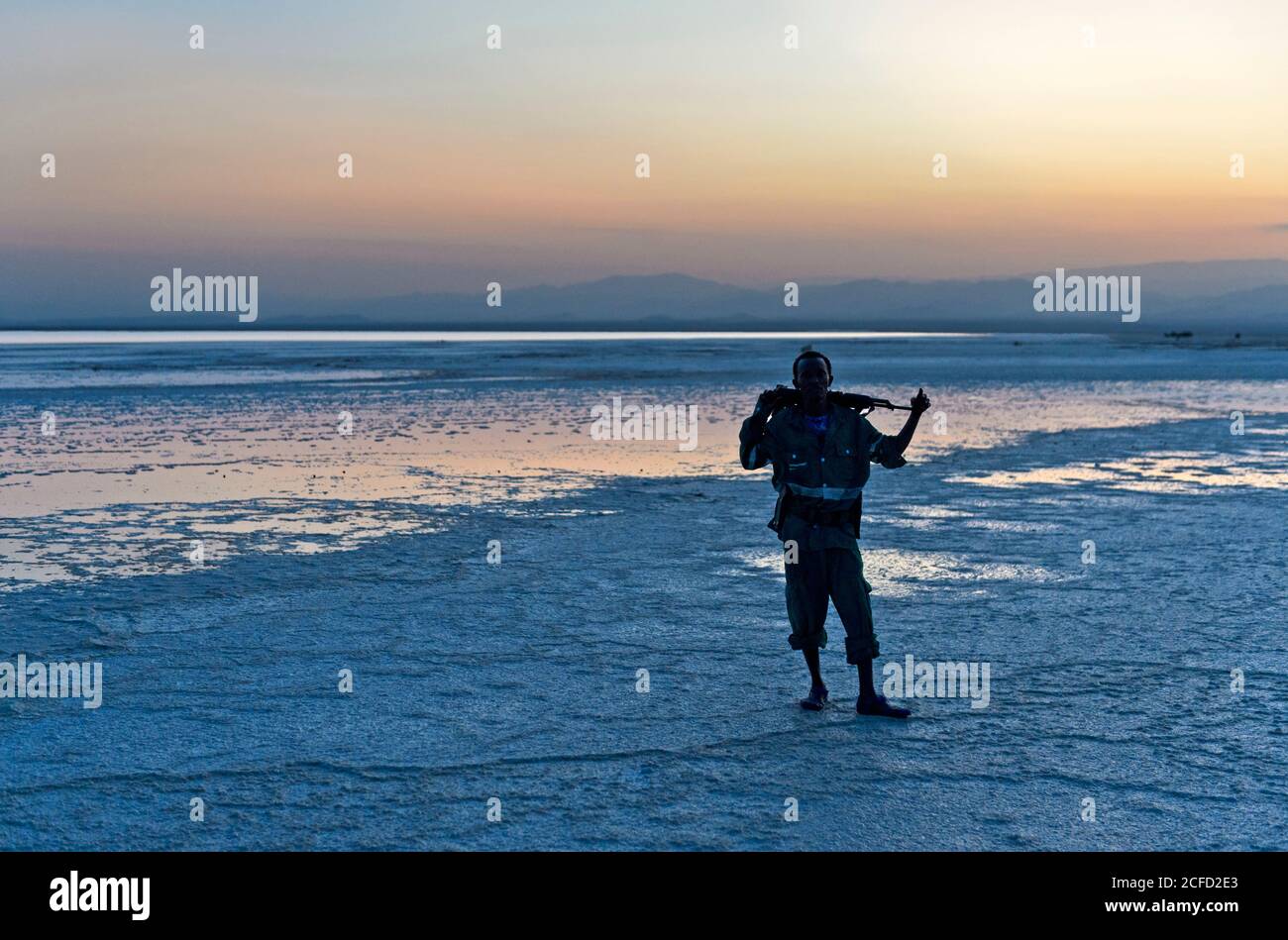Garde de sécurité avec Kalachnikov au lac de sel d'Assale au coucher du soleil, Hamadela, Danakil Dépression triangle Afar, Ethiopie Banque D'Images