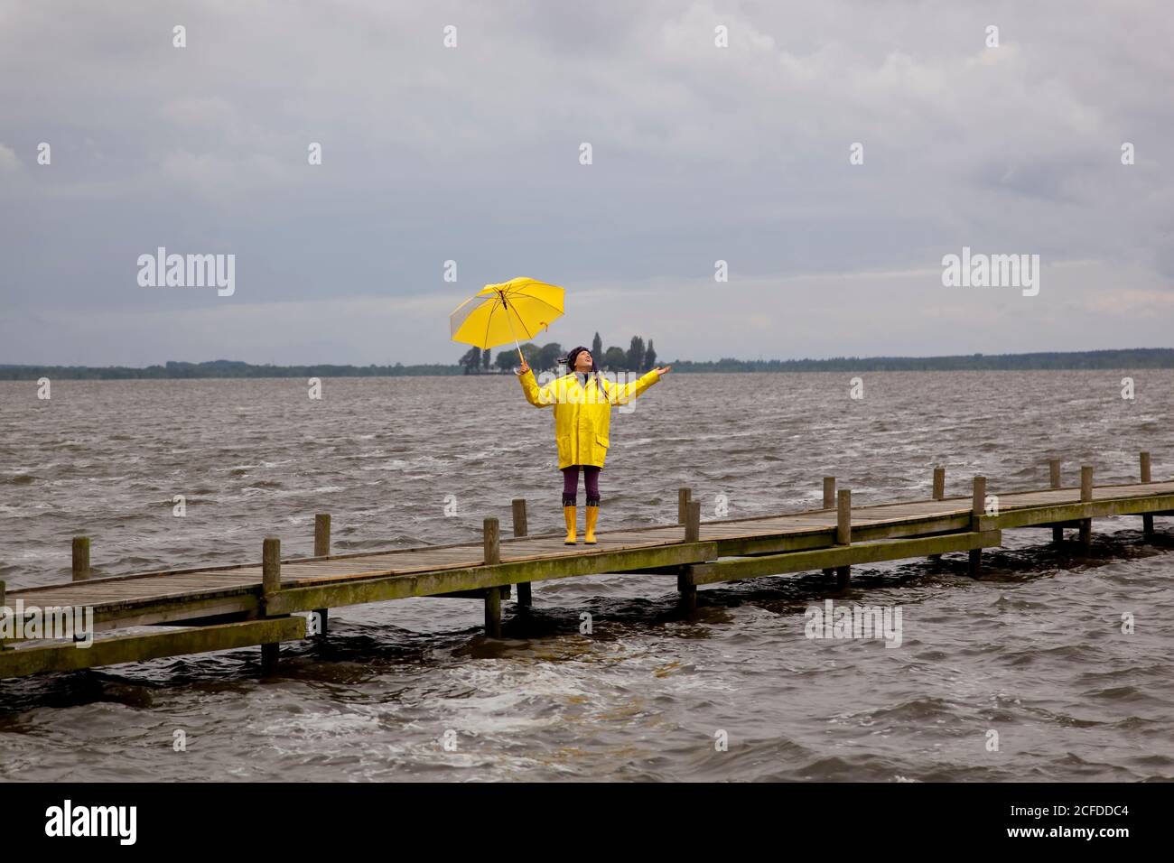 La jeune femme sur la jetée contrôle 0b il pleut encore. Steinhuder Meer, Allemagne Banque D'Images